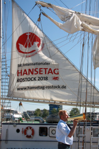 „Setzt das Stagsegel!“ Mit diesem Kommando von Kapitän Wolfgang Fusch beginnt das Auftakeln der „Greif“ und damit das Rostocker Pierfest. Foto: Büro Hanse Sail/Annika Schmied